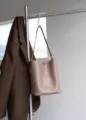 Elegant leather bucket bag in taupe with shoulder strap and metal clasp. Perfect for daily commute. - Khaki