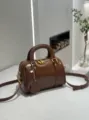 Vintage brown leather Boston bag with top handles, gold hardware, and cross-body strap. - Caramel color