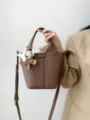 Brown leather bucket bag with cute bear charm, top handle and crossbody strap for women. - Andora Brown