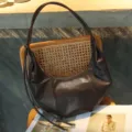 Detail view of brown leather hobo shoulder bag with pleated design and elegant metal ball straps. - Chocolate