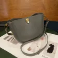 Elegant grey leather saddle bag with chic gold-tone lock hardware for women stylish daily use. - Premium Grey