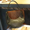 Detailed view of dark green retro slouchy hobo shoulder bag with unique metal ball strap accents. - Yucca Green