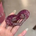 Gros plan détail d'une barrette à cheveux cœur en strass rose étincelant avec cristaux. - Rose Dégradé