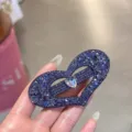 Gros plan détail d'une pince à cheveux cœur en strass violet scintillant avec cristal. - Violet