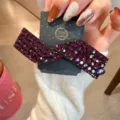 Vue détaillée de la splendide pince à cheveux nœud en strass violets sur support. - Fuchsia