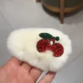 Vue rapprochée de la jolie pince à cheveux en peluche blanche avec des cerises en strass. - Blanc