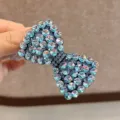 Gros-plan de la pince à cheveux nœud strass avec des cristaux bleus scintillants et un beau style. - Bleu