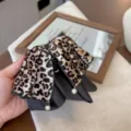 Nahaufnahme des Retro-Leopardenmuster-Haargreifers mit elegantem Perlenschleifen-Design. - Helle Farbe