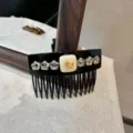 Rhinestone hair comb detail showing sparkling crystal stars and cute golden dog charm accent. - Black