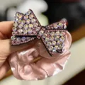 Chouchou en satin rose avec nœud en strass étincelant pour queues de cheval et chignons. - Rose