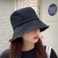 Gedetailleerd overzicht van de casual denim bucket hat met stijlvolle rafelige rand. - Rafelig spijkerstof [zwart]
