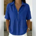 Detail view of the blue short sleeve zip V-neck shirt with chest pockets and linen texture. - Blue