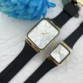 Gros plan de la montre quartz couple rectangulaire avec bracelet en silicone noir et boîtier or. - Cadran Blanc Bracelet Noir (Hommes)