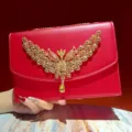 Luxuriöse rote Abendtasche mit goldenem Strass-Flügel-Ornament, elegante Kettentasche. - Rot