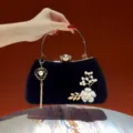 Borsa da sera in velluto nero con manico dorato, chiusura con strass e ciondolo di perle. - Nero