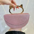 Sac de soirée pailleté rose avec poignée en métal en forme d'oreilles de chat dorées, élégant. - Rose