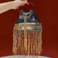 Elegant black sequin fringe bucket bag with gold metal handle and stylish evening design. - Black