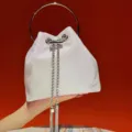 White sparkling evening bucket bag variant featuring stylish metal ring handle and chains. - White