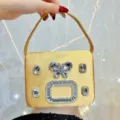 Elegante borsa da sera in raso dorato con preziosa fibbia di cristallo e strass - Oro
