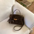Vintage bruine suède schoudertas voor dames stijlvolle handtas met een schattige bedel. - Met Hanger / S / Bruin