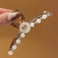Nahaufnahme der eleganten Haarklammer aus Harz mit Perlen, Strass und Schmetterling Detail. - Khaki