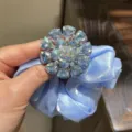 Chouchou en satin bleu clair avec accessoire de broche fleur en cristal étincelant. - Bleu