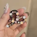 Rhinestone hair claw clip detail shot, featuring sparkling crystal stones on mini heart design. - Pink Gray