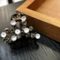 Detail view of a sparkling rhinestone hair claw clip, small size for bangs and styling. - Gray