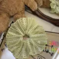 Close-up detail of light green lace hair scrunchie, sweet mesh ruffle hair accessory. - Green