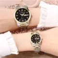 Two-tone metal couple quartz watch set with black dial, rhinestone markers, and date. - Two Tone Gold Black Face Couple Pair