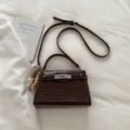Dark brown crocodile pattern top handle crossbody bag with metallic turn lock closure. - With Pendant / Brown