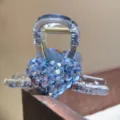 Blue rhinestone heart hair claw detail, transparent acrylic hair clip for women close up. - Blue