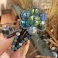 Vue détaillée d'une pince à cheveux florale en strass étincelante avec des cristaux colorés. - Style Fleur