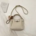 Beige commuting shoulder crossbody bag with turn-lock closure and cute bear pendant. - White With Pendant