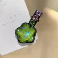 Gros plan de la pince à cheveux fleur en cristal vert avec des strass brillants et pince-bec. - Vert