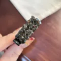 Gros plan détaillé d'une pince à cheveux étincelante en strass sombres, style élégant. - Gris