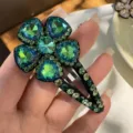 Gros plan détail de pince à cheveux fleur strass bleu scintillant, accessoire élégant femme. - Vert