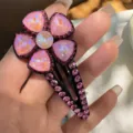 Gros plan détail de la pince à cheveux fleur cristal rose, strass étincelants. - Rose