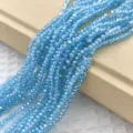 Gedetailleerd aanzicht van glinsterende lichtblauwe gefacetteerde kristallen kralen voor sieraden. - 150 stuks / Meerblauw AB