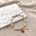 Gedetailleerde close-up van de kleurrijke kralenarmband met een schattige rode sterhanger. - 9*9 Ster Hanger Armband / 17cm