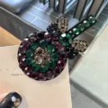 Vue rapprochée et très détaillée d'une belle pince à cheveux sucette en strass colorés. - Vert foncé