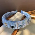 Elegante diadema de terciopelo azul claro con cristales, detalle de joyería retro. - Azul Niebla