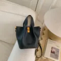 Stylish black leather bucket bag with top handles and gold-tone hardware for women. - No Pendant / Black