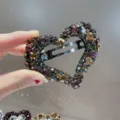 Gros plan détaillé d'une pince à cheveux cœur en cristal étincelant avec strass. - Mélange Rose Gris