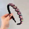 Gedetailleerd overzicht van de luxe strass haarband met sprankelende roze stenen. - Rozerood