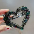 Vue detaillee de la pince a cheveux coeur strass luxe avec cristaux brillants etincelants. - Irisé