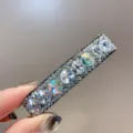 Gros plan sur le détail de la barrette à strass étincelante, montrant de superbes cristaux. - Blanc