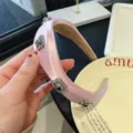Détail d'un serre-tête rose en satin, orné de magnifiques strass et de détails métalliques. - Rose