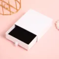 Vista dettagliata dell'elegante portagioie bianco a cassetto con interno in morbido velluto. - Bianco [Modello base] / 9*9*3cm (Con Spugna)