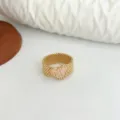 Primo piano di un elegante anello di perline fatto a mano con cuore rosa dorato. - Cuore Rosa / Oro
